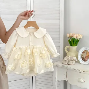 Detail of cream baby dress featuring 3D floral appliqués and Peter Pan collar