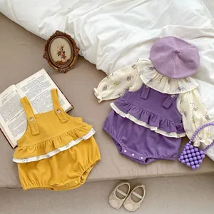 Flat lay of baby corduroy rompers with floral shirts and matching beret accessories