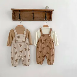 Detalle de petos de pana para bebé con estampados de osos en perchas de madera