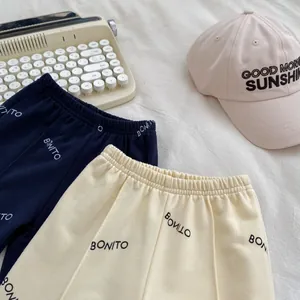 Λεπτομέρεια από παιδικό παντελόνι joggers σε μπλε και κρεμ με γράμματα BONITO και λάστιχο