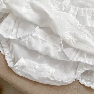Pagliaccetto neonata bianco in cotone con ricami floreali e dettaglio con fiocco