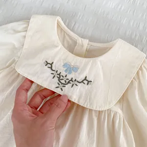 Besticktes Mädchenkleid in Cremeweiß mit Peter-Pan-Kragen und floralem Schleifendetail