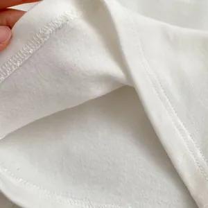 Detailed close-up of high-quality overlock stitching and knit fabric texture on baby clothes