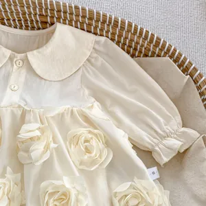 Close-up of baby girl long sleeve romper dress with 3D floral details and Peter Pan collar