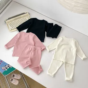 Detail von gerippter Baby-Hauskleidung in Schwarz, Rosa und Cremeweiß-Farben