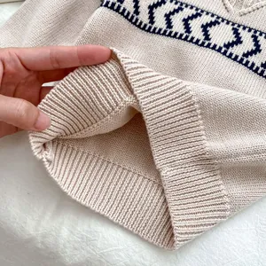 Close-up of ribbed cuffs on toddler knitted sweater with navy geometric jacquard pattern