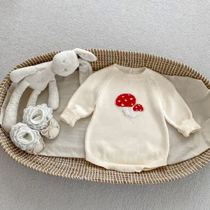 Detail of baby knitted mushroom romper with lace shoes in a cozy woven basket