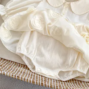 Detailed view of baby dress romper with 3D rose appliques and peter pan collar