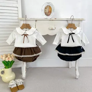 Detail der Baby-Mädchen-Baumwollsets mit Peter-Pan-Kragen und Spitzen-Bloomers auf Holzbügeln