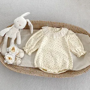 Détail de barboteuse fleurie pour bébé avec col en dentelle dans un panier