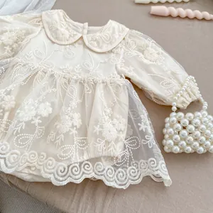 Dettaglio body neonata in pizzo ricamato con colletto Peter Pan e bottoni a pressione