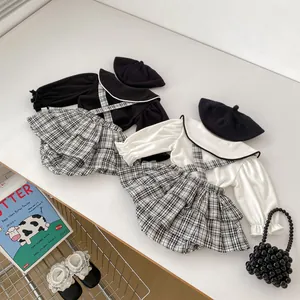 Dettaglio completo neonata con salopette a quadri, balze e camicia a maniche lunghe