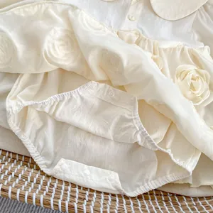 Detailed view of baby romper featuring 3D chiffon roses and convenient crotch snap buttons