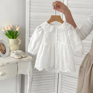 Dettaglio body neonato bianco con colletto Peter Pan in pizzo e ricami di fiocchi