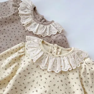 Détail de bodies fleuris pour bébé avec col volanté brodé et tissu en coton doux