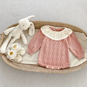 Detailaufnahme des Strick-Babystramplers mit Spitzenkragen und Druckknöpfen im Korb