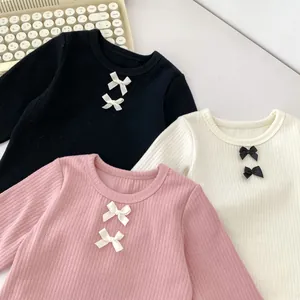 Detailansicht von Baby-Langarmshirts aus Rippstrick mit süßen Schleifen-Details