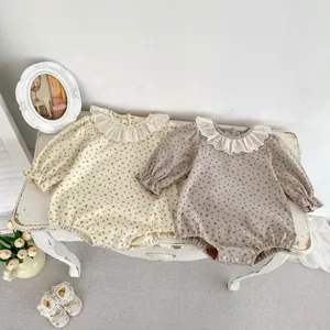 Détail de barboteuses fleuries pour bébé avec cols volantés et poignets élastiques