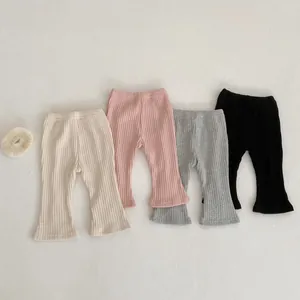 Dettaglio dei pantaloni a zampa in maglia a coste per bambine in quattro colori tenui
