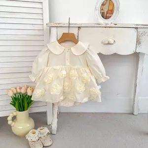 Detail of cream baby romper dress with 3D floral petals and Peter Pan collar