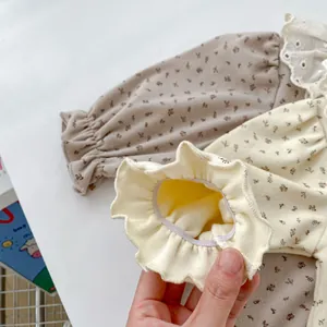 Détail des poignets élastiques à volants sur body bébé à fleurs en coton doux et souple