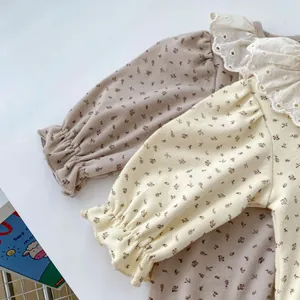 Détail du body bébé fleuri avec col à volants en dentelle et poignets élastiques