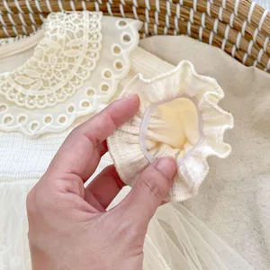 Detail showing elastic ruffled cuffs and delicate lace neckline on baby romper