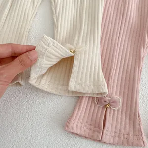 Dettaglio dei leggings svasati a costine con fiocchi in mesh e spacchi laterali per bambina