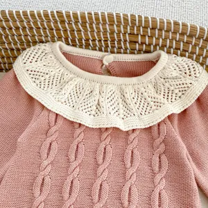 Detail der rosa Baby-Strickjacke mit elfenbeinfarbenem Lochmuster-Volantkragen