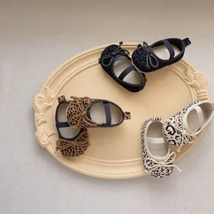 Drei Paar Baby-Mary-Jane-Schuhe mit Leopardenmuster und Schleifen auf einem Tablett