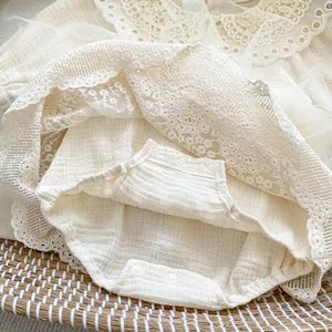 Detail of baby romper with delicate lace edges, tulle layers and bottom snap buttons