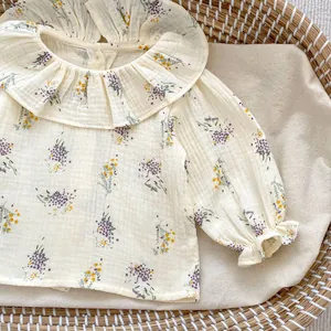 Detailed close-up of floral baby blouse with ruffled collar and soft cotton texture