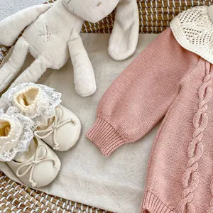 Detailansicht Baby Strickstrampler in Altrosa mit passenden Spitzenschuhen und Schleifen