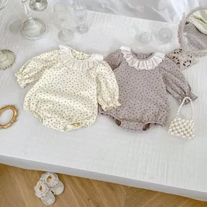 Détail de barboteuses à fleurs pour bébé avec cols en dentelle et boutons pression