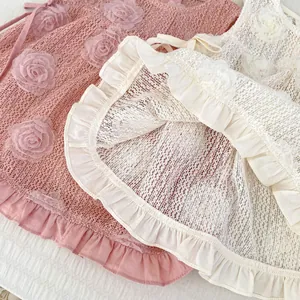 Détail de la robe en dentelle pour bébé avec fleurs 3D et bordure à volants