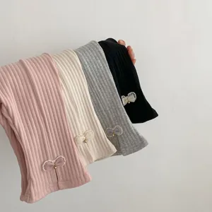 Dettaglio di leggings a coste per bambine con fiocchi in mesh e accenti di perline dorate