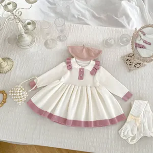 Detailed flat lay of a girls knit dress with contrast pink collar and frill details