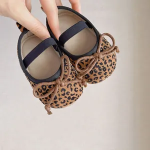 Detailansicht der Baby-Babyschuhe mit Leopardenmuster, brauner Schleife und Gummiband
