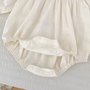 Détail du body bébé montrant la fermeture à trois pressions à l'entrejambe et les bords élastiques