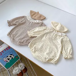 Détail de bodies fleuris pour bébé avec col en dentelle et poignets élastiques