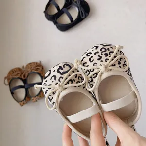 Detail von Baby-Mary-Janes mit Leopardenmuster, weicher Sohle und dekorativen Schleifen