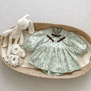 Detail of floral baby bodysuit with Chinese-style collar and brown bow accents