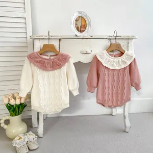 Detail eines Baby-Strickstramplers mit Rüschenkragen und Zopfmuster-Struktur