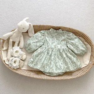 Detailed close-up of floral baby romper with elegant standing collar and white buttons
