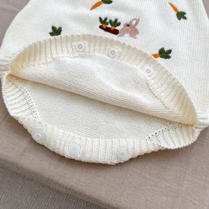 Détails d'un barboteuse tricotée pour bébé avec boutons-pression et broderie lapin