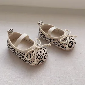 Detailaufnahme von Baby-Leopardenschuhen mit elastischen Riemen und Schleifendeko
