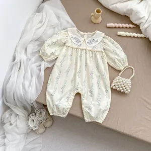 Detail of floral baby girl romper with Peter Pan collar and delicate flower embroidery