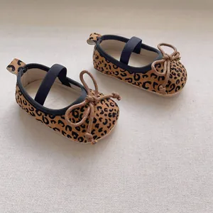 Detail von Baby-Schuhen mit Leopardenmuster, Schleife und elastischem Riemen