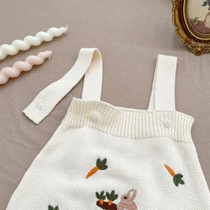 Détail d'une barboteuse en maille pour bébé avec broderie lapin et carotte