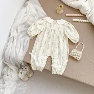 Flat lay of floral baby romper with white Peter Pan collar and elastic cuffs in INS style
